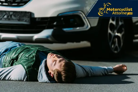 Injured man lies on road near car.